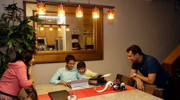 Shubham Banerjee, center left, works on a prototype for his braille printer joined by his family including mom Malini, left, sister Anoushka, 8, center right, and dad Neil, right, at home Tuesday, Jan. 6, 2015, in Santa Clara, Calif. (AP Photo)