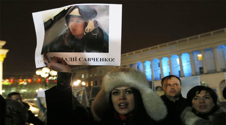 File. A woman holds a poster depicting Ukrainian pilot Nadezhda Savchenko during a rally in Kiev, Ukraine. (AP Photo)