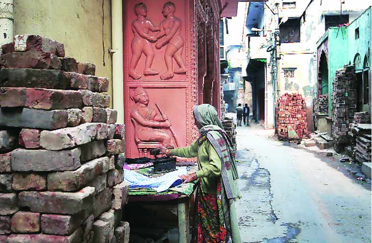 A woman irons clothes on the streets of Khampur village. (Source: Oinam Anand)