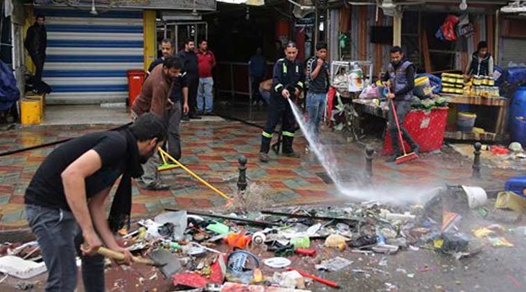 Baghdad municipality workers help clean up the site of a suicide bombing that targeted a street filled with hardware stores, killing over 20 people and wounding at least 45, in the Iraqi capital's southeastern neighborhood of New Baghdad. (Source: AP photo)