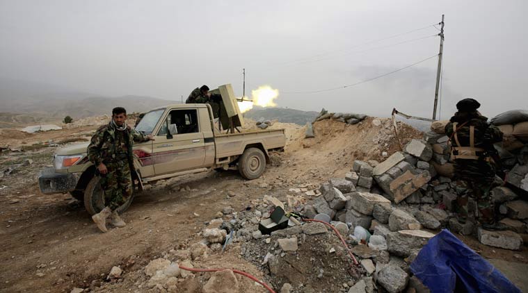 In this Thursday Jan. 29, 2015 photo, a Kurdish peshmerga fighter fires a weapon towards positions of the Islamic State group who are 500 meters or half a mile away, overlooking the strategic town of Sinjar, northern Iraq. Peshmerga fighters representing the lawful authorities of Iraqi Kurdistan fume against what they see as the recklessness of their allies in militias drawn from neighboring Syria and Turkey making progress painful and raising doubts about whether these groups can work together. At stake is ownership of Sinjar, the town that once was home to many of Iraq’s Yazidi religious minority. (AP Photo/Bram Janssen)