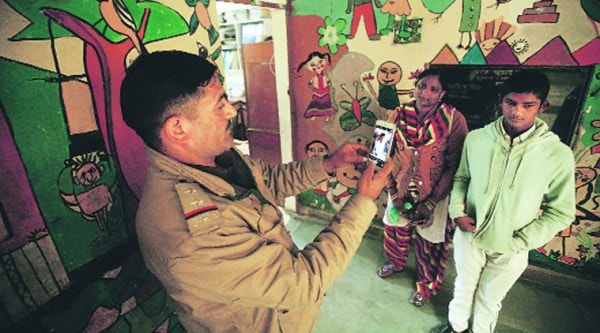 S-I Rakesh Pundir takes a photograph of Rahul and Shakuntala. The 17-year-old was reunited with his mother within a week. (Express photo by Praveen Khanna)