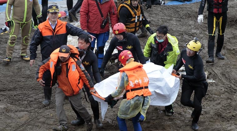 Search and rescue divers carry a recovered body at the site of a commercial plane crash in Taipei, Taiwan, Friday, Feb. 6, 2015. (AP Photo)