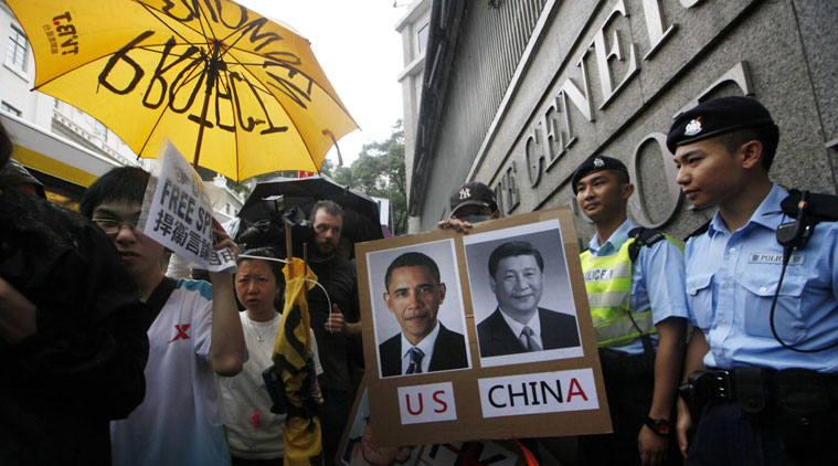 FILE - In this June 15, 2013 photo, supporters of NSA leaker Edward Snowden hold portraits of U.S. President Barack Obama, left, and Chinese President Xi Jinping during a demonstration outside the Consulate General of the United States in Hong Kong, accusing the U.S. government of infringing people's rights and privacy. (Source: AP)