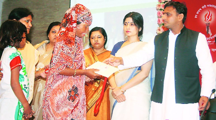  Akhilesh Yadav hands over a cheque of Rs 3 lakh to an acid attack victim  as Kannauj MP Dimple Yadav looks on, in Lucknow on Sunday. (Source: express photo by Pramod Adhikari)