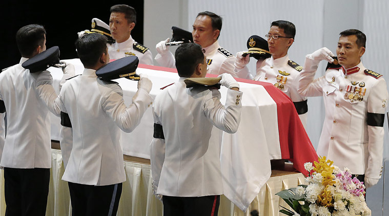 Pallbearers ready themselves by removing their headdress before carrying the coffin of the late Lee Kuan Yew during a state funeral held at the University Cultural Center, Sunday, March 29, 2015, in Singapore.