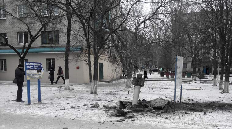 A resident passes by an unexploded rocket in a living area in Kramatorsk, Ukraine, Tuesday, Feb.10, 2015. Ukrainian President Petro Poroshenko told Parliament that Russian-backed rebels launched an artillery strike on the town of Kramatorsk, which is more than 50 kilometers (30 miles) away from the front line. The government-controlled Donetsk regional administration said eight people were killed, while 58 people were injured after 32 rockets were launched by separatists. (AP Photo)