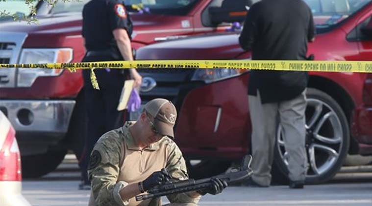A police officer recovers a rifle while sweeping through the parking lot of a Twin Peaks restaurant Tuesday, May, 19, 2015, in Waco, Texas. (Source: AP)