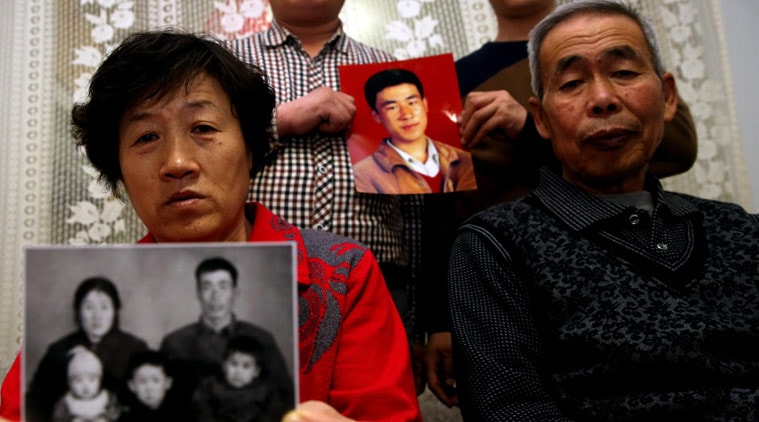 In this Dec. 16, 2014 photo, brothers of Huugjilt, a wrongly executed man, hold a photo of him, at rear, while his parents, in front, hold a family photo in Hohhot in northern China's Inner Mongolia Autonomous Region. Huugjilt, who was 18 when he was convicted and executed in 1996 on charges of rape and murder, was formally exonerated by the Chinese government in Dec. 2014, and the police officer who oversaw the original case has been charged with using torture to coerce a confession. In a report released Wednesday, May 13, 2015, Human Rights Watch says that police abuse in order to extract confessions continues to be a serious problem despite measures to reform the legal system. (Chinatopix Via AP) CHINA OUT