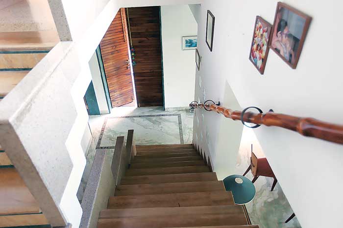 A door made of mangoo wood and a bamboo handrail along the staircase