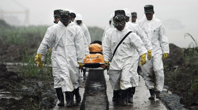 Rescuers carry the bodies of victims recovered from the capsized tourist ship in Yangtze River in Jianli county in central China's Hubei province Wednesday June 3, 2015. Chinese authorities deployed scores more divers and a large crane as they escalated efforts Wednesday to recover more than 410 people believed to be trapped inside an overturned river cruise ship. (Chinatopix Via AP) 