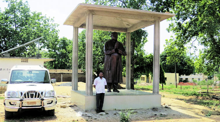 Eldest son Deepak stands beside Mahendra Karma’s statue. (Source: Express photo by Ashutosh Bhardwaj)