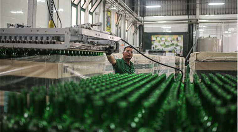 In this Wednesday, May 27, 2015 photo, a worker observes bottles on a production line at the Gianaclis winery, one of Egypt's main wineries, in the Nile Delta, north of Cairo, Egypt. (AP Photo/Mosa'ab Elshamy)