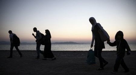 Migrants walk along a beach on the Greek southeastern island of Kos, Wednesday, Aug. 12, 2015. Dozens of people from the Middle East are arriving on the Greek holiday island of Kos from nearby Turkey, joining thousands of refugees camped under wretched conditions. (AP Photo/Yorgos Karahalis)