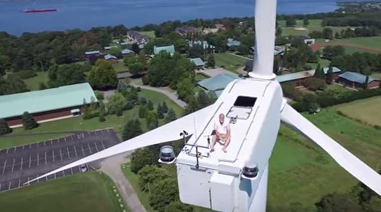 Drone Captures Monk Relaxing Atop Wind Turbine 175 Ft Above The Ground