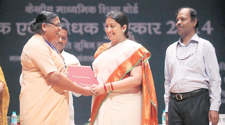 HRD Minister Smriti Irani gives away the Central Board of Secondary Education Awards to a teacher in New Delhi on Thursday. For innovations in teaching, 34 teachers were awarded and 16 mentors were felicitated for promoting quality. Tashi Tobgyal