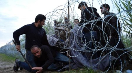 Syrian refugees cross into Hungary underneath the border fence on the Hungarian - Serbian border near Roszke. (Source: AP)