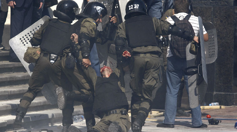 Police officers carry their injured colleague after grenade exploded during a clash between protesters and police after vote to give greater powers to the east, outside the Parliament, Kiev, Ukraine. (Source: AP)