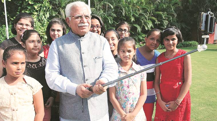 Haryana Chief Minister Manohar Lal clicking a selfie with girls as they called on him to thank him for launching `Beti Bachao-Beti Padhao' campaign at his residence in Chandigarh on Friday, July 17 2015. Express photo