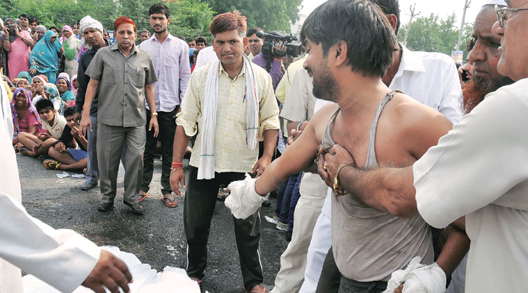 Jitender with the bodies of his two children on the highway, Wednesday. (Source: Express photo by Manoj Kumar)