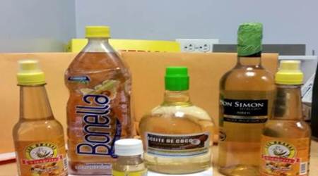 In this Oct. 5, 2015 photo provided U.S. Customs and Border Protection, bottles labeled oil and vinegar that contain liquid cocaine sit on a table in at private search room at New Yorks John F. Kennedy International Airport. Law enforcement officials say a passenger who flew into the airport had the bottles stored in his luggage. (U.S. Customs and Border Protection via AP)