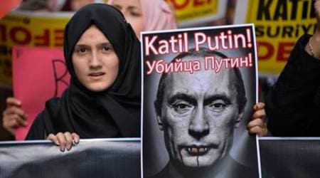 A demonstrator holds a picture depicting Russian President Vladimir Putin during a protest against Russian military operations in Syria, in Istanbul, Turkey, Saturday, Oct. 3, 2015. The picture reads both in Turkish and Russian: 'Murderer Putin'. In ramping up its military involvement in Syria's civil war, Russia appears to be betting that the West, horrified by Islamic State's atrocities, may be willing to tolerate Syrian President Bashar Assad for a while, perhaps as part of a transition. (AP Photo)