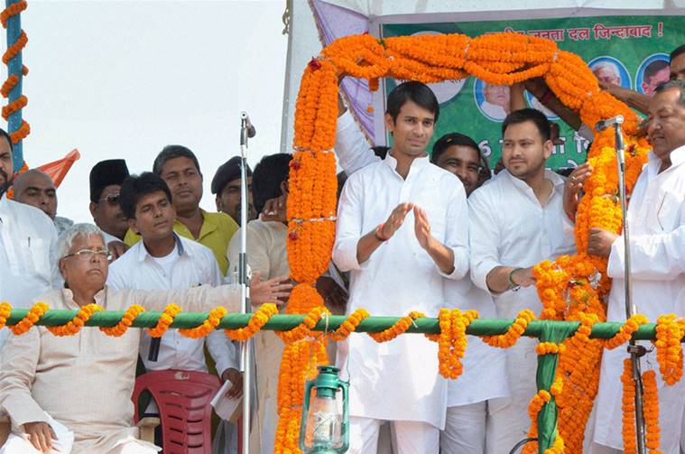 Hajipur : RJD chief Lalu Prasad with sons Tejaswi Yadav and Tej Pratap at a rally after the latter filed nomination papers from Mahula assembly constituency, in Hajipur on Monday. PTI Photo (PTI10_5_2015_000264B)