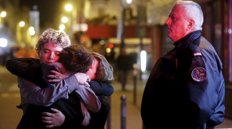 People hug on the street near the Bataclan concert hall following fatal attacks in Paris, France, November 14, 2015. Gunmen and bombers attacked busy restaurants, bars and a concert hall at locations around Paris on Friday evening, killing dozens of people in what a shaken French President described as an unprecedented terrorist attack.    REUTERS/Christian Hartmann