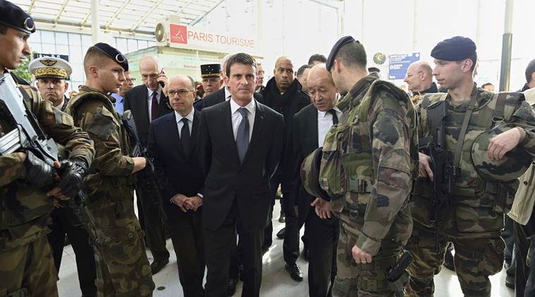 French Prime minister Manuel Valls (C) arrives with French Defence minister Jean-Yves Le Drian (R), French national rail company SNCF Chairman Guillaume Pepy (L Rear) and French Interior minister Bernard Cazeneuve (L) speak with soldiers at the Gare du Nord railway station in Paris, France, November 15, 2015. REUTERS/Eric Feferberg/Pool