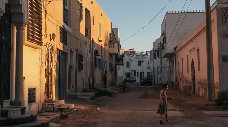 In this Friday, Oct. 30, 2015 photo, a girl walks home after sunset, at Hara Kbira, the main Jewish neighborhood on the Island of Djerba, southern Tunisia. (AP Photo/Mosa'ab Elshamy)