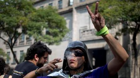A supporter of marijuana legalization smokes outside the Supreme Court in Mexico City, Wednesday, Nov. 4, 2015. Mexico's court ruled Wednesday that growing, possessing and smoking marijuana for recreation are legal under a person's right to personal freedoms. (AP Photo/Eduardo Verdugo)