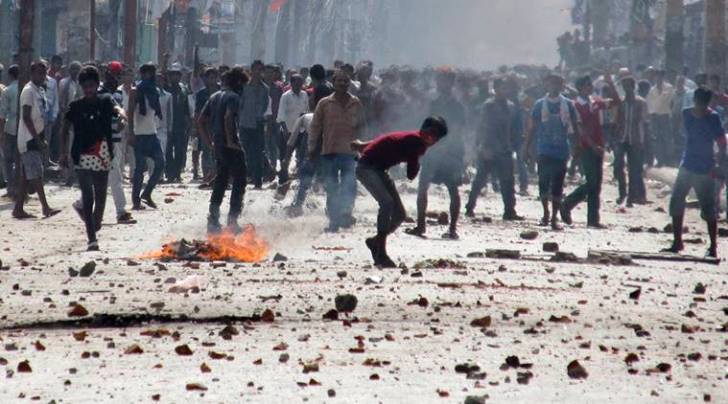 Ethnic Madhesi protesters throw stones and bricks at Nepalese policemen in Birgunj, a town on the border with India, Nepal, Monday, Nov. 2, 2015. Ethnic protesters demonstrating against the new constitution clashed with police in south Nepal Monday which left at least one person killed and several more injured, officials said. (AP Photo/Jiyalal Sah)