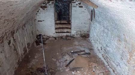 This Nov. 3, 2015 photo provided by the New York City Department of Design and Construction shows the inside of a centuries-old burial vault containing human remains beneath a street in New York's Greenwich Village neighborhood according to anthropologists and archeologists. Two vaults were discovered by workers replacing a water main in the heart of New York University's campus. One of the roughly 15-by-18-foot crypts contained skeletons and skulls of between 9 and 12 people pushed into a corner while more than a dozen stacked wooden coffins can be seen in the second one.  (New York City Department of Design and Construction via AP)