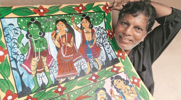 Yakub Chitrakar shows a scroll painting depicting incidents from Ramayana at his home at Noya in West Midnapore. (Source: Express photo by Subham Dutta)