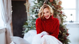 smiling woman in red sweater over christmas tree background no alt set