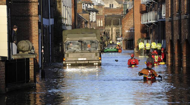 Members of the Army and rescue teams wade through floodwater after the River Ouse and the River Foss burst their banks, in York city center, England, Sunday, Dec. 27, 2015.  (Source: AP)