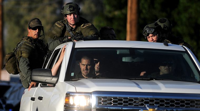 Authorities search an area Wednesday, Dec. 2, 2015, following a shooting that killed multiple people at a social services center for the disabled in San Bernardino, Calif. (James Quigg/The Victor Valley Daily Press via AP)