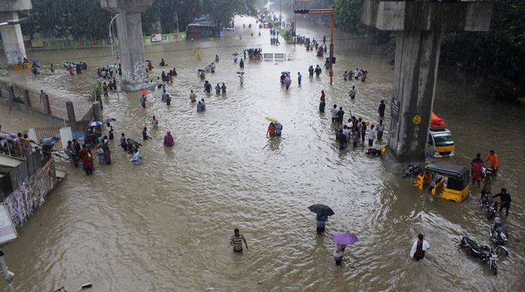 People wade through a flooded road in Chennai, Tamil Nadu, India, Wednesday, Dec. 2, 2015. Weeks of torrential rains have forced the Chennai airport in southern India to close and have cut off several roads and highways, leaving tens of thousands of people stranded in their homes, government officials said Wednesday. (AP Photo)