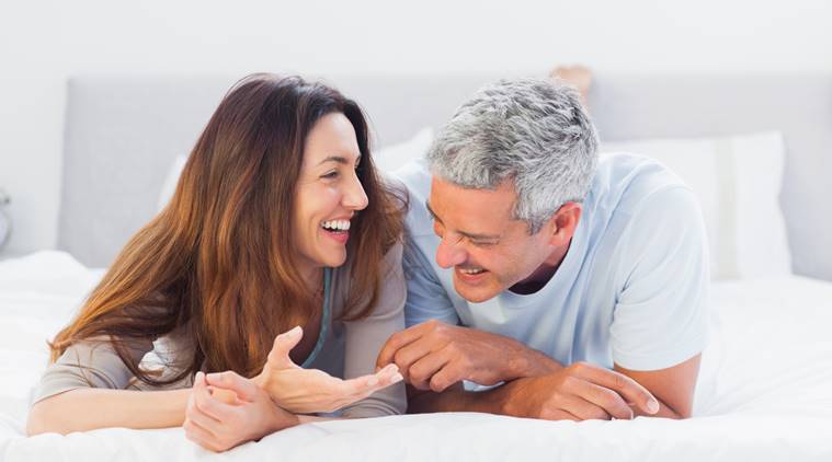 Cute couple lying on bed talking together