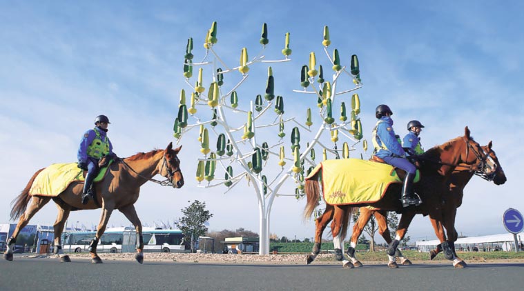 At the venue of COP21 outside Paris, French mounted police patrol beside a ‘Wind Tree’, each of whose leaves functions like a mini wind turbine. (Source: AP)