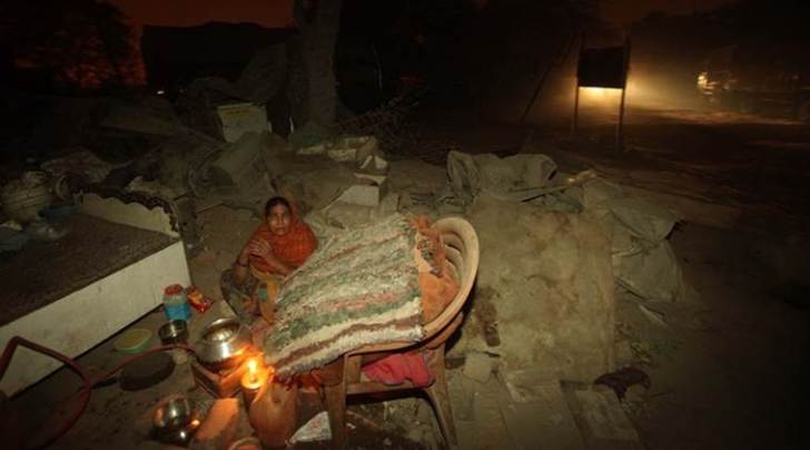 People who are affected by the demolition drive at the slums next to a railway line in Shaku Basti area on Sunday night. Express photo by Amit Mehra. 13 December 2015