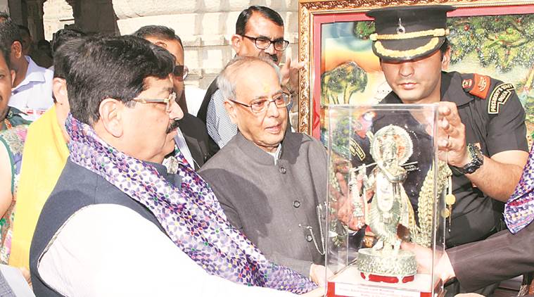 President Pranab Mukherjee accepts an idol of Lord Krishna from Rajya Sabha MP Parimal Nathwani, also the vice president of Dwarka Mandir Vyavasthapan Samiti, during a visit to the temple Wednesday.  (Photo released by Reliance Industries)