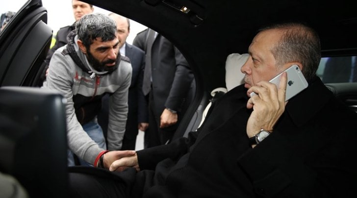Turkish President Recep Tayyip Erdogan, right, takes Vezir Cakras by hand while speaking on his mobile phone inside his car stationed over the Bosporus Bridge in Istanbul, Friday, Dec. 25, 2015. Erdogans office says the Turkish president has talked Cakras out of jumping off a bridge to commit suicide. Television footage on Friday showed Erdogans motorcade stopping over Istanbuls Bosporus Bridge where a man was apparently contemplating jumping off. An official from Erdogans office told the Associated Press that Vezir Cakras was depressed because of family issues. (Yasin Bulbul, Presidential Press Service Pool via AP Photo )
