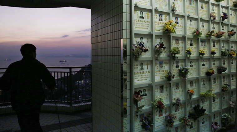 In this Nov. 22 photo, a man walks past a wall of niches for cremated remains in the background at a public columbarium in Hong Kong. In tightly-packed Hong Kong, the dead are causing a problem for the living. Limited land to build on and soaring property prices mean Hong Kong is fast running out of space to store the dead. (AP Photo/Kin Cheung)