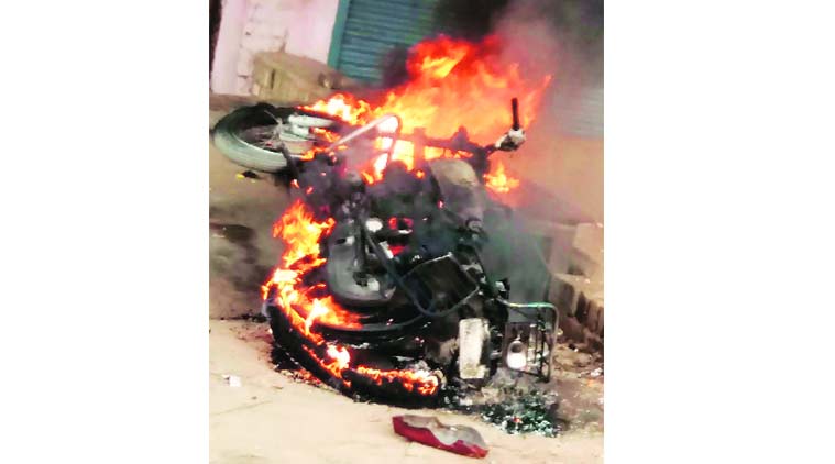 A motorcycle is set ablaze during the clash in Fatehpur on Thursday. PTI 
