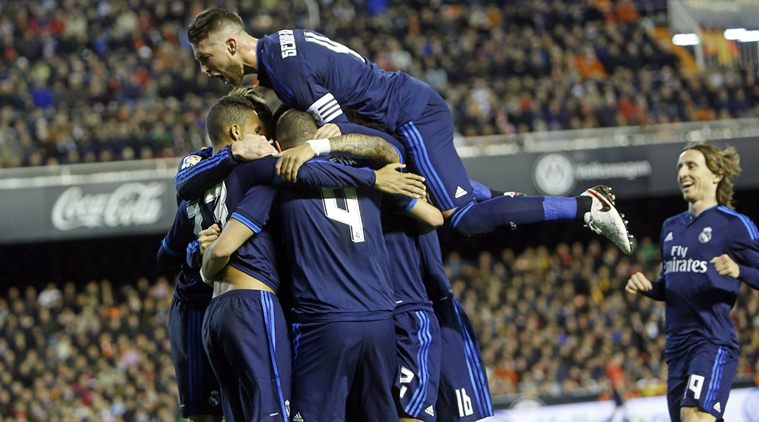 Real Madrid's Karim Benzema, back to the camera no. 4, celebrates with teammates after scoring against Valencia during a Spanish La Liga soccer match at the Mestalla stadium in Valencia, Spain, Sunday, Jan. 3, 2016. (AP Photo/Alberto Saiz)