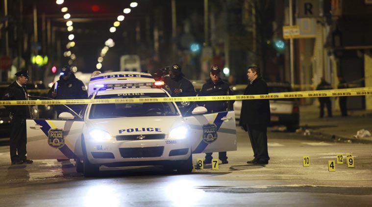 Officials investigate the scene of a shooting Friday, Jan. 8, 2016, in Philadelphia. A Philadelphia police officer was shot multiple times by a man who ambushed him as he sat in his marked police cruiser, authorities said. (AP Photo)