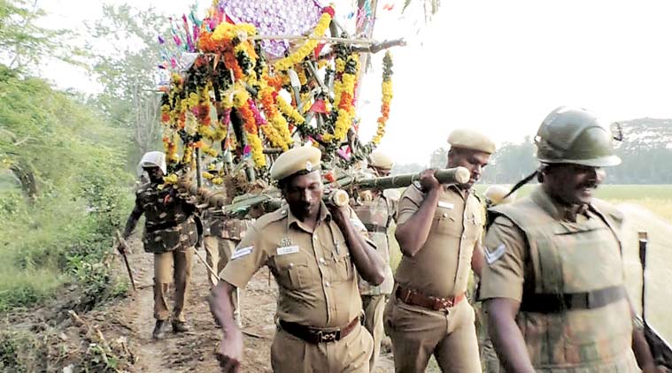 Policemen carry the body of Chellamuthu through the forest path for burial at Vazhavur, Nagapattinam.