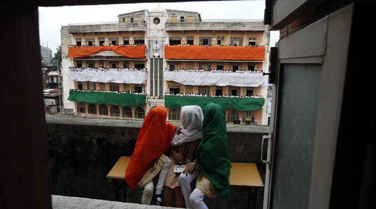 Students look at the decoration of their school at Astodia in Ahmedabad with tricolour on the eve of Independence Day in Ahmedabad. Express Photo by Javed Raja. 14.08.2013.