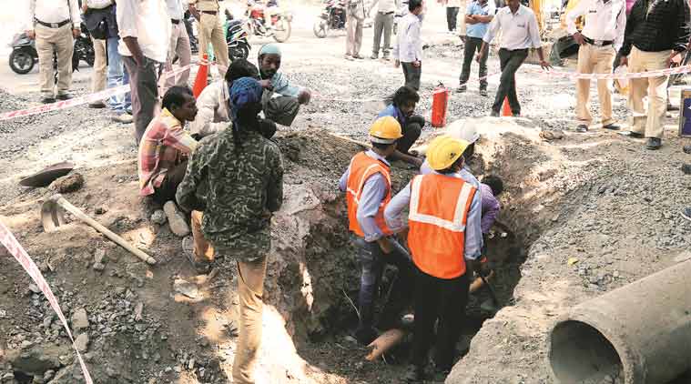 Fire brigade, Maharashtra Natural Gas Limited officials and police team up to restore a gas pipeline that leaked after an earthmover machine used for digging the road ruptured it, near Model Colony, on Thursday. (Express Photo Digvijay Sabne)